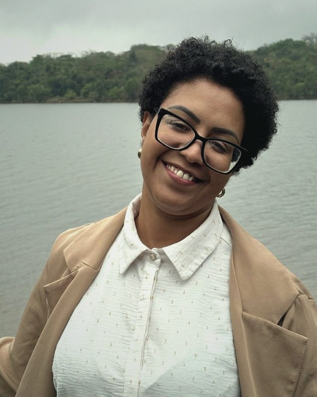 Retrato de Karla Dias, psicóloga e neuropsicóloga, sorrindo ao ar livre